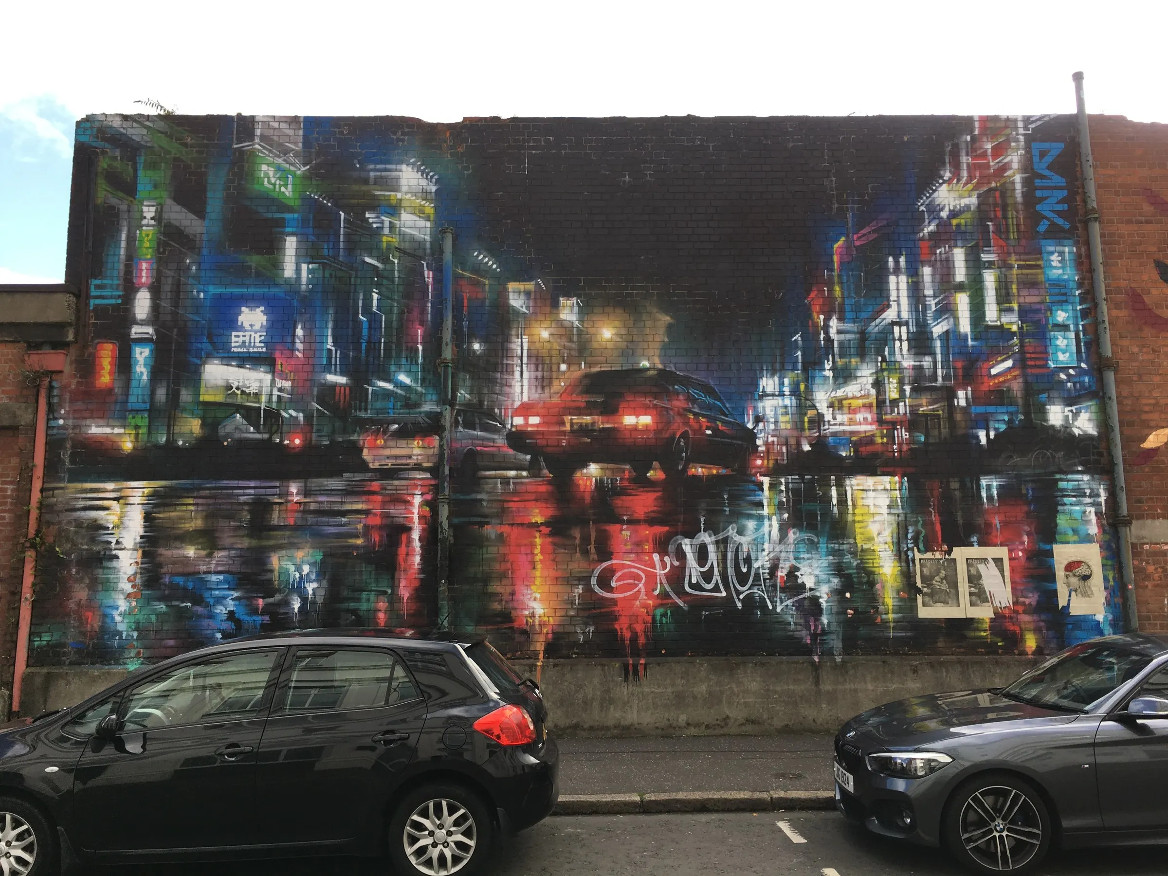 A photorealist mural of a night city filling a gable wall