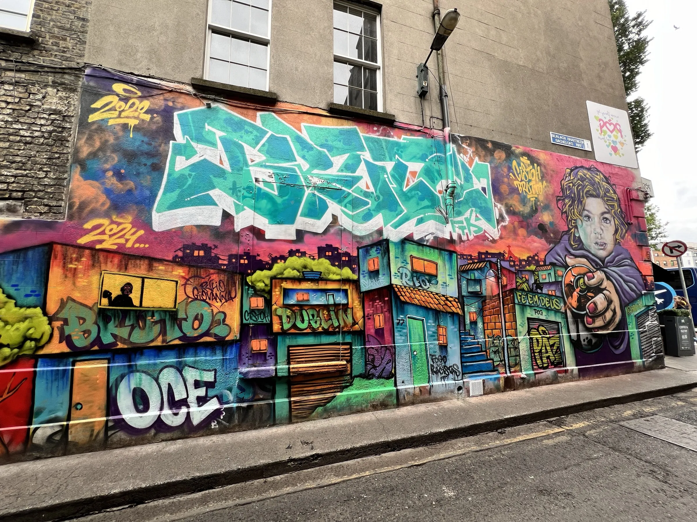 A street wall covered end to end in layered graffiti
