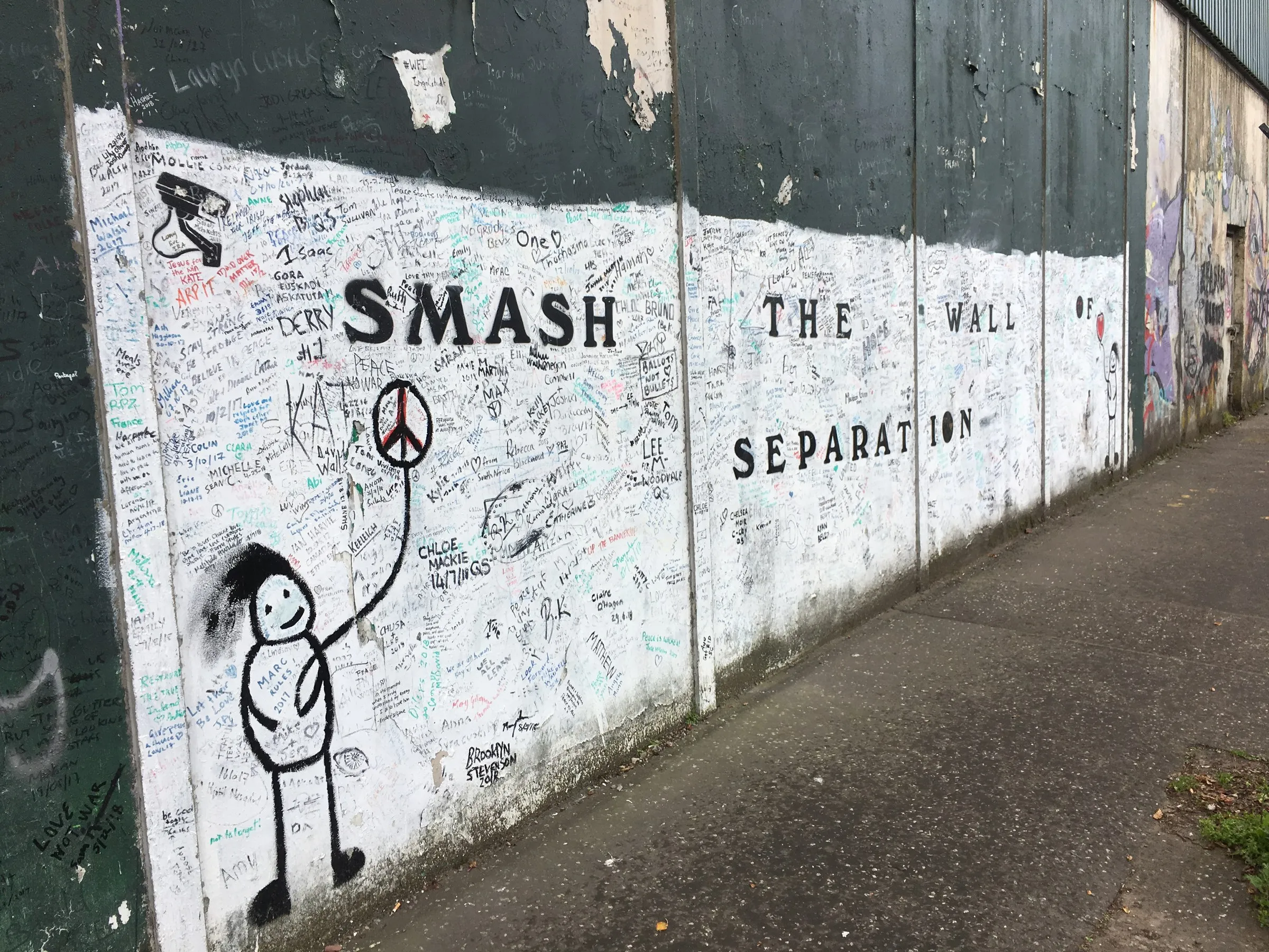 A peace wall painted with the words Smash the wall, separation